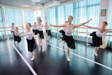 Adult female ballet dancers practice balance in bright studio light © TRAVELARIUM