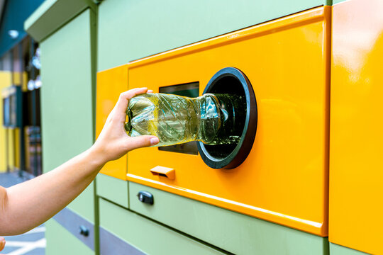 Recycling station collecting bottle through return opening.