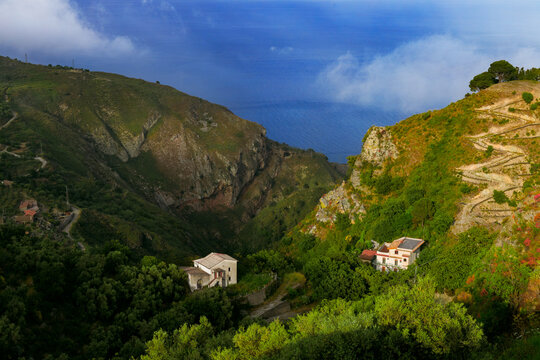 Scenic coastal landscape with hillside villas nestled in lush green mountains above the sea