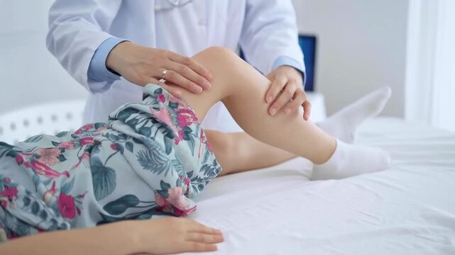 Doctor and kid patient. Orthopedist examining girl's knee in medical clinic. Medicine and health care