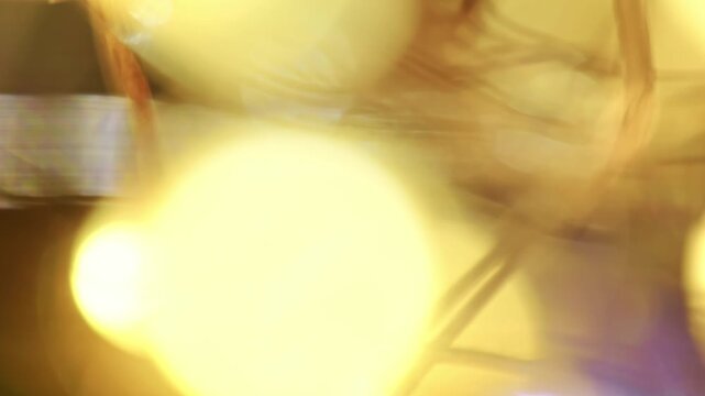 Macro shot of glowing copper wire fairy lights emitting warm golden illumination with soft blurred bokeh.