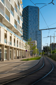 Tram tracks curve between modern buildings in Vienna, Austria, showing urban architecture and transport infrastructure along an empty city street.