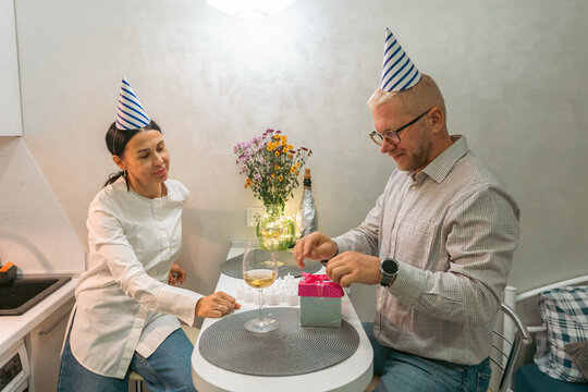 Here's a title attempting to follow all instructions: Birthday Couple Party Hats Gift Opening; Kitchen; Celebration