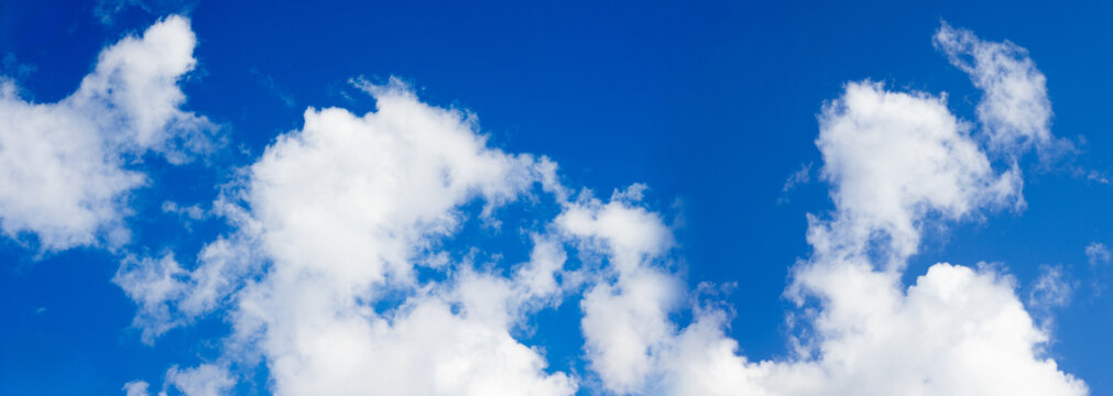 Bright sky with white clouds during the day over a clear blue background