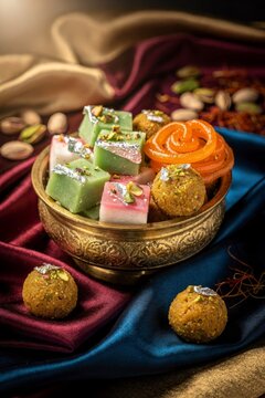 Traditional Indian Mithai sweets in brass bowl on silk
