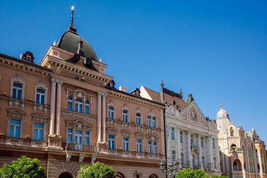 The ornate Neo-Renaissance and Art Nouveau facades along Trg Slobode (Liberty Square) under a clear blue sky in Novi Sad, Serbia.