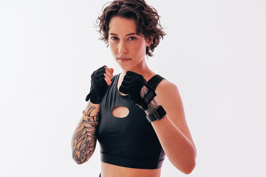 Portrait of a young slim female in a fighting stance looking at the camera