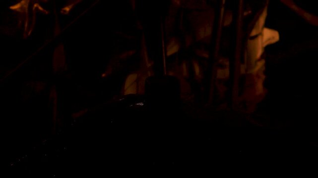Red emergency warning beacon light flashing on vehicle roof at night in dark environment with rain droplets
