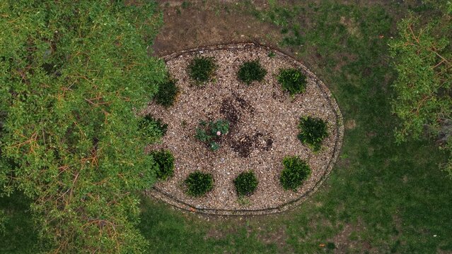 Aerial view of a circular garden bed with gravel, small shrubs, and a central plant, surrounded by grass and trees in Cherry Creek, Denver, Colorado, United States.