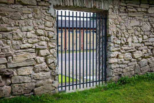 Tall Metal Gate Set in a Weathered Historic Stone Wall