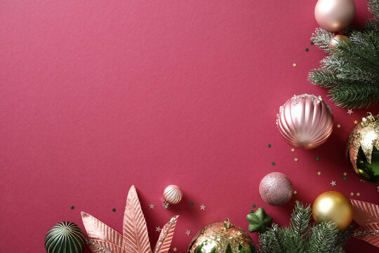 Christmas baubles and pine branches on burgundy background