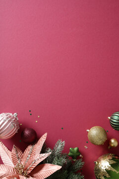 Christmas baubles and flower on burgundy background with copy space