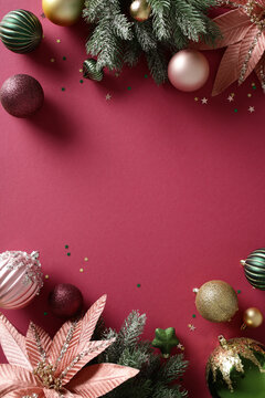 Christmas bauble decoration with copy space on burgundy background. Flat lay, top view, vertical