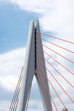 Tall angular cable‑stayed bridge pylon with radiating red stay cables
