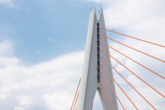 Tall angular cable‑stayed bridge pylon with radiating red stay cables