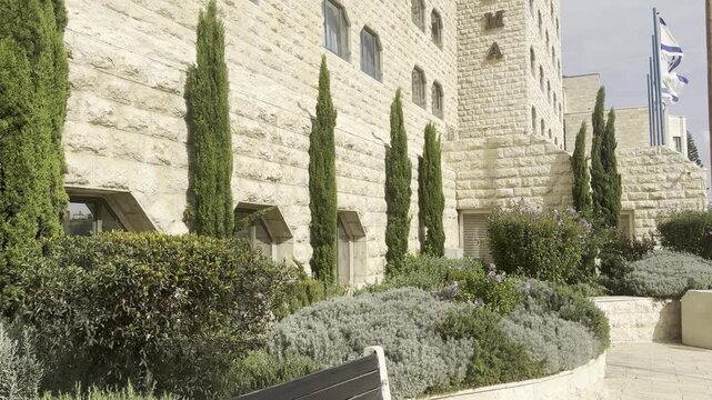 Jerusalem, Israel, 26 September 2026. Dan Panorama Hotel exterior made of authentic Jerusalem stone with cypress trees and Israel flags