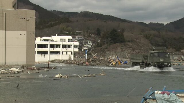 Military Truck Drives In Flood Waters In Aftermath Of Tsunami In Japan
