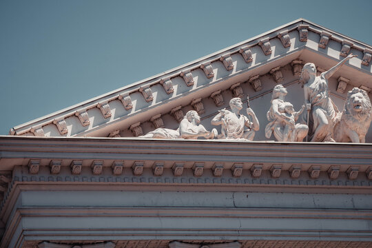 Classical building pediment with stone statues sculptures and architectural details