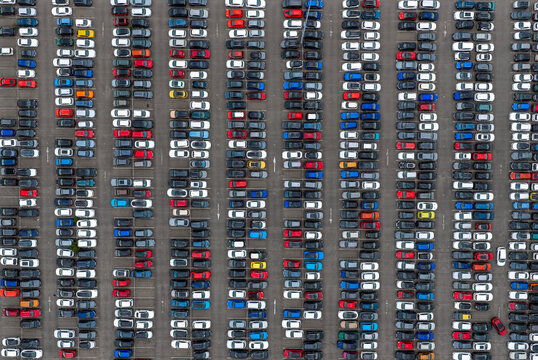 Aerial view of a large parking lot filled with numerous cars parked in organized rows in the United Kingdom.