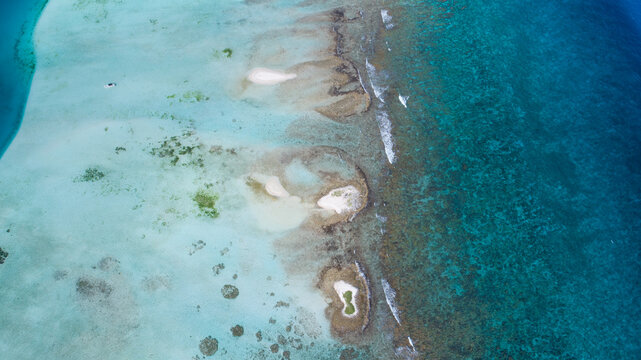Aerial view of Los Roques archipelago featuring turquoise shallow waters, coral reefs, and small sandy cays in the Caribbean Sea in Los Roques, Dependencias Federale, Venezuela.