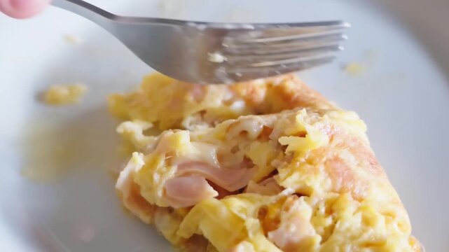 Person eating a delicious omelette for breakfast