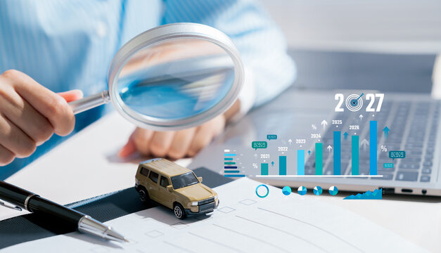 Focused business professional using magnifying glass analyzing car sales data chart projection feeling optimistic about growth potential