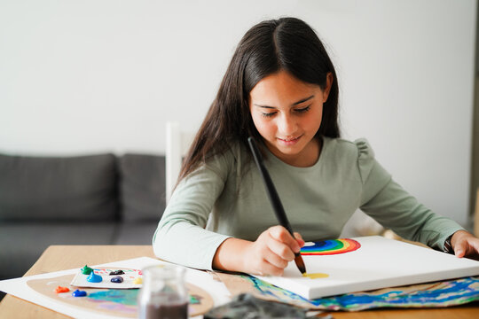 Female kid painting a rainbow at school - Education, art and creativity for children concept - Main focus on face - UGC content