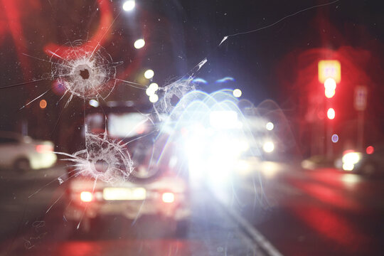 A broken car windshield with bullet or stone holes.