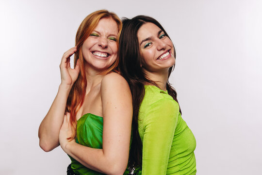 Two friends laughing back to back