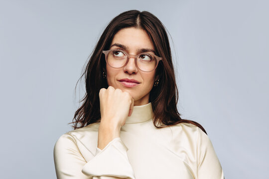 Woman thinking with hand on chin