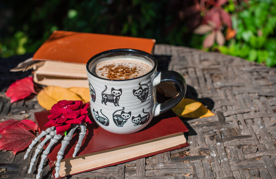 Halloween Still Life with Pumpkin, Skeleton Hand and Ceramic Cat Mug