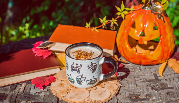 Halloween Still Life with Pumpkin, Skeleton Hand and Ceramic Cat Mug
