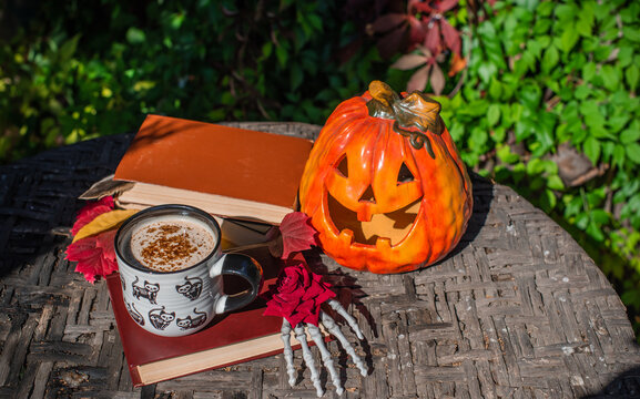Halloween Still Life with Pumpkin, Skeleton Hand and Ceramic Cat Mug