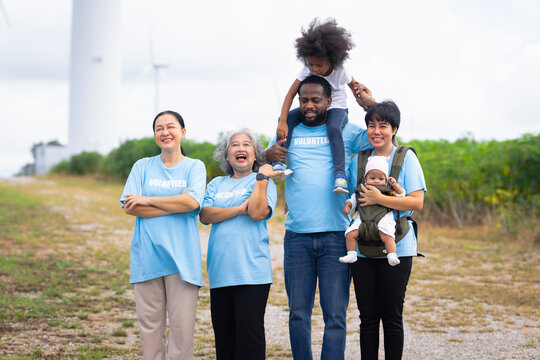 Family smiles together in  bright, open field