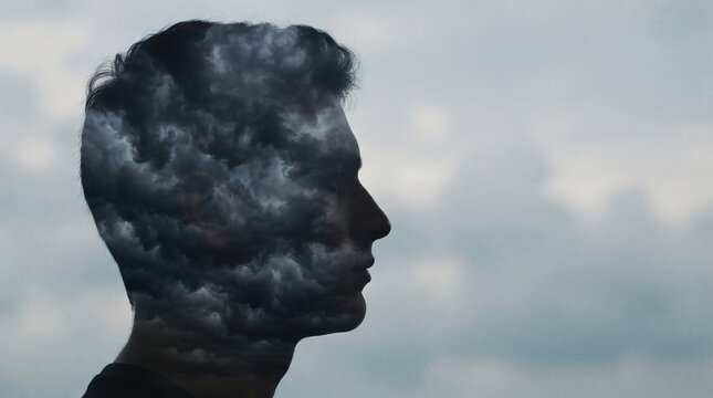 Silhouette of a man's profile with stormy clouds overlay, representing internal turmoil and a troubled mind, symbolizing a mental state of distress.