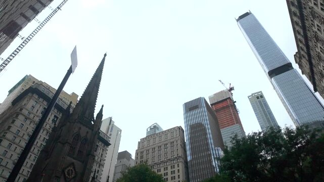 Wall street skyscrapers and trinity church in new york city's financial district, a hub of global economy, stock market, and corporate business enterprise