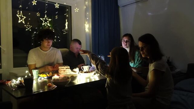 Family gathering around a table with food and decorations in a cozy