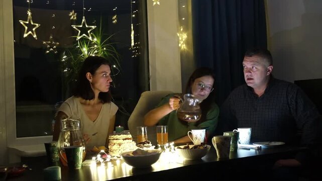 Friends gather for a special occasion with cake, drinks, and lights