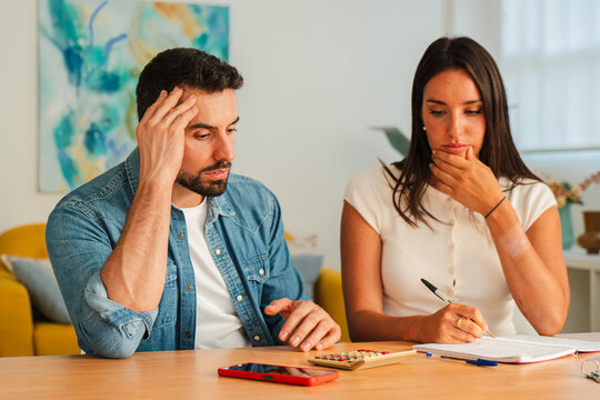 Two adults collaborate over papers and a notebook, sketching ideas and comparing notes while concentrating on a shared project. The scene highlights problem solving, cooperation, and clear