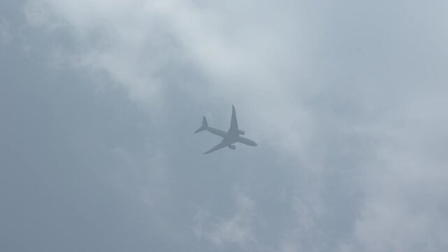 Commercial Airplane Flying Through Overcast Cloudy Sky