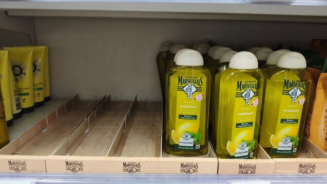 Royan, France - July 25, 2026: E.Leclerc ROYAN CEDEX. Bottles of Marseille soap displayed on a retail shelf with empty spaces, featuring lemon scent and brand logo visible
