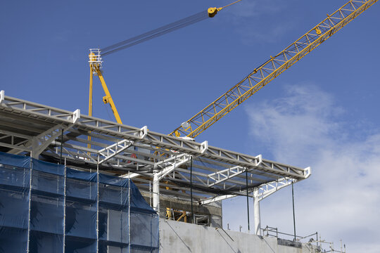 Construction crane building steel structure blue sky industrial architecture site Construction crane and steel structure building site blue sky industrial architecture with modern design