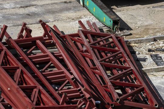 Red steel beams construction material industrial site metal structure outdoor building framework heavy equipment urban development engineering sunlight