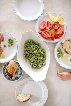 Top Down View of Mediterranean Lunch with Fava Beans, Tomatoes and Children Hands in Corfu, Greece