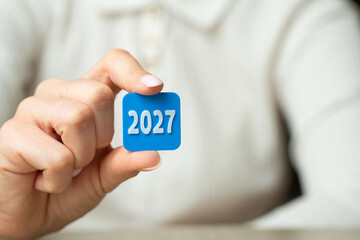 Fototapeta premium 2027 year in the hand of a businesswoman. Business plans and economic forecasts. Strategic vision, market expectations and financial planning. Corporate strategy content, investment and future trend
