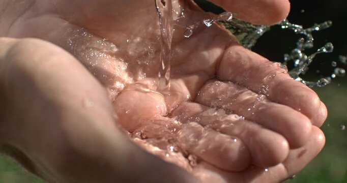 Both hands gently joined as water flows over them, creating a cinematic symbol of unity, healing, acceptance and renewal. Slow motion captures the intimate connection between hands and water.