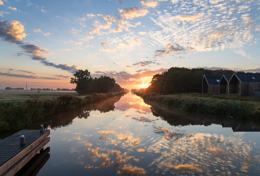 A tranquil sunrise over a canal in the countryside. Meerstad, the Netherlands.
