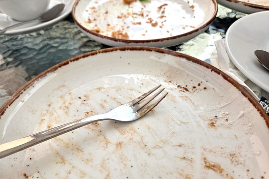 Empty Plates and Fork on Table Indicating Finished Meal at Cafe or Restaurant