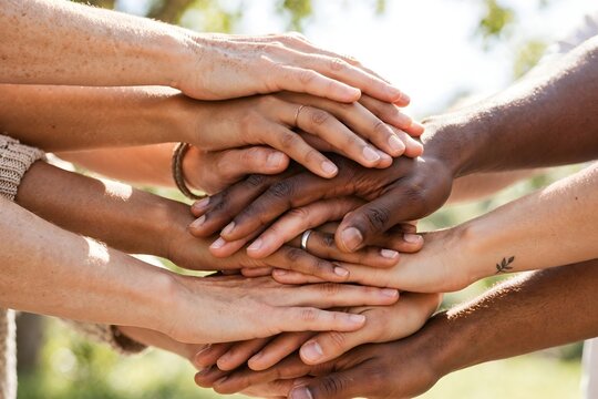 Diverse hands stacking together, teamwork unity close-up