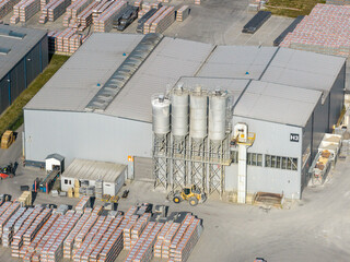 Industrial warehouse with silos and goods storage, material production facility © Marcin
